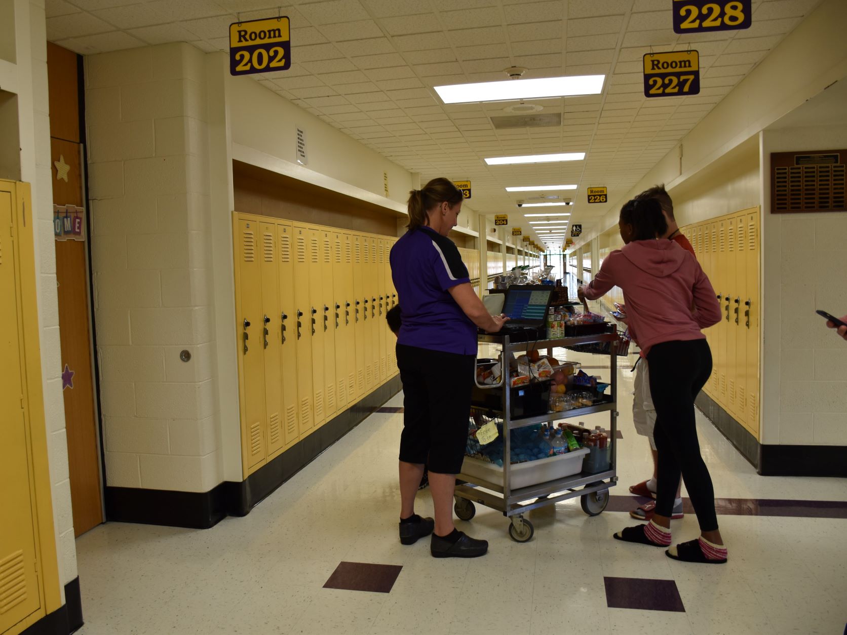 Students getting breakfast from a cart in the hallway