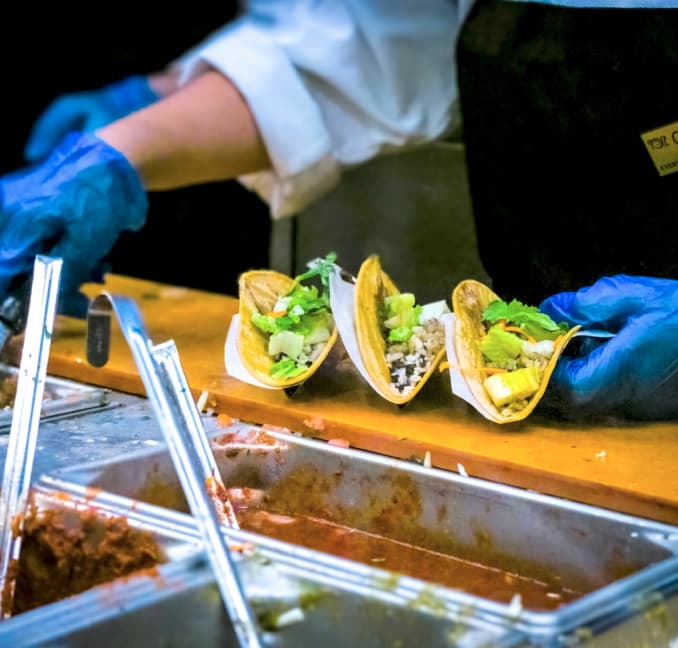 A school professional serving tacos