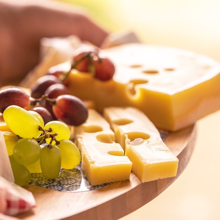 Grapes and cheese on a wooden board