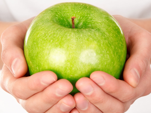 Hands holding a green apple